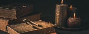Obrazek wyróżniający do artykułu - mądre cytaty. Na zdjęciu widzimy zbliżenie na stare książki o postrzępionych krawędziach stron. Obok znajduje się kałamarz z piórem, co sugeruje tradycyjne narzędzia do pisania używane w dawnych czasach oraz świece. Zdjęcie to emanuje uczuciem nostalgii i szacunku dla literatury oraz mądrości ksiąg. Może to wywoływać refleksje nad historią i znaczeniem zachowywania oraz przekazywania wiedzy przez pokolenia.
