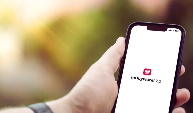 Smartfon z uruchomioną aplikacją mObywatel 2.0 trzymany w dłoni, symbol nowoczesnej wygody i bezpieczeństwa cyfrowego – obraz nawiązujący do pytania jak dodać e-legitymację dziecka w mObywatel.
